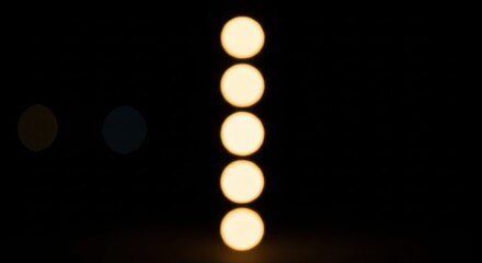 Abstract vertical line of defocused yellow lights against black background