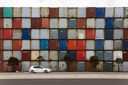 Car in front of colourful shipping containers