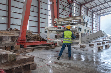 Industrial worker in manufacturing plant with heavy machinery for concrete tunnels covers