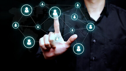A business professional touches a digital interface with connected user icons over a world map to illustrate recruitment and global collaboration.
