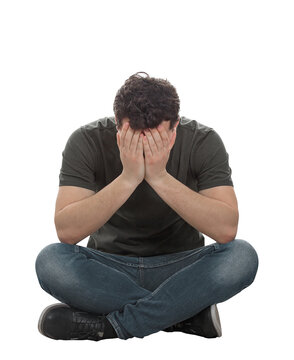 Stressed and depressed man seated on the floor covers face feeling desperate and anxious. Male full length portrait isolated on transparent background