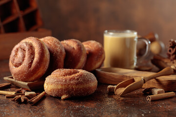 Swedish cinnamon rolls and coffee latte on a brown background.