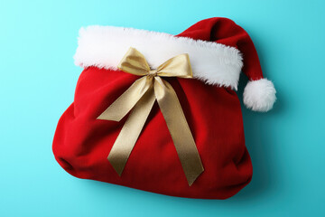 Christmas bag red sack gold bow Santa hat festive decor gift wrap holiday surprise winter season celebration cheerful mood Christmas bag tied with