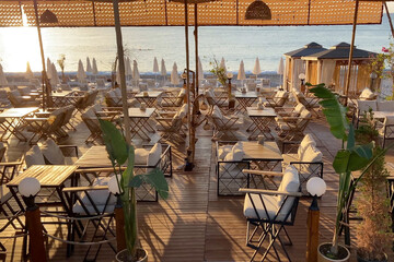 Empty summer beach cafe with sea view in sunset