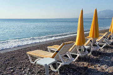 Empty beach with sun loungers and sunbathing areas and sea in sunny summer day, calm video