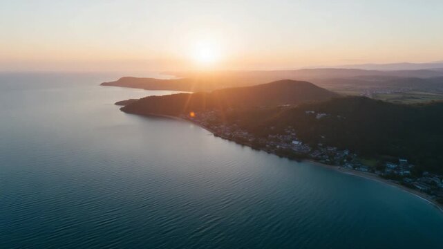 Drone view of the sea coast with blue water and hills at sunset