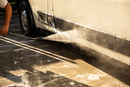 High-pressure cleaning of a van on a sunny day, showcasing advanced car wash technology, thorough maintenance, and vehicle hygiene (part of the &ldquo;at the car wash&rdquo; series).