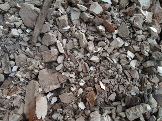 A pile of broken red bricks and fragments of concrete. Pile of debris of a torn down building
