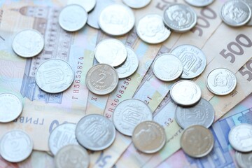 Ukraine money coins lying on mixed hryvnia banknotes. Finance background concept.