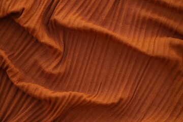 Bright orange fabric background from a piece of crumpled clothes