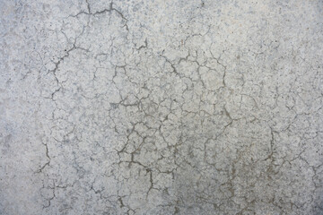 Concrete wall with dense crack network forming a natural abstract pattern. Weathered surface emphasizes urban decay and texture.
