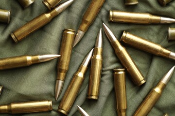 Many rifle bullets on military camo green fabric background