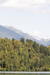 Scenic view of Lake Bled in Slovenia with a white villa on the forested shore, turquoise water, and wooded hills in the background.