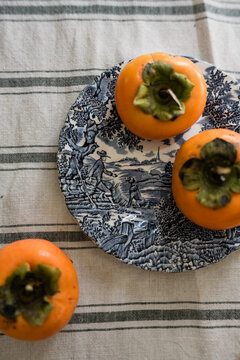 persimmons on a blue and white plate
