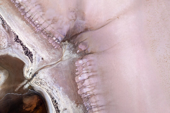 Aerial view of abstract salt lake patterns in soft pink and beige tones