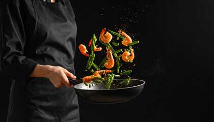 Chef Flipping Shrimp and Green Beans in a Frying Pan with a Dramatic Black Background