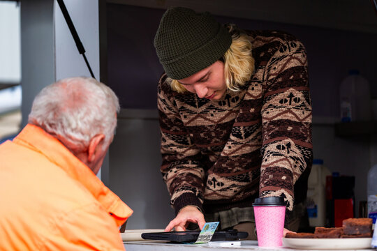 Workman buying warm drink before work from small business coffee van