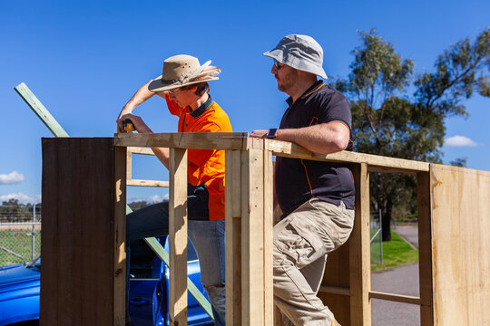 Trade apprentice and teacher working on construction of ticket booth