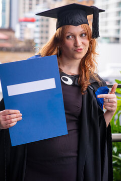  genZ graduate making a funny pose  with her graduation certificate