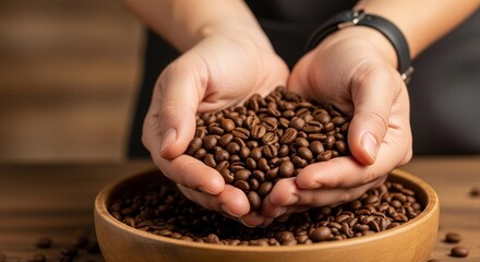 A close-up of a pair of hands holding roasted coffee beans over a wooden bowl, showcasing the rich texture and aroma of freshly prepared coffee beans