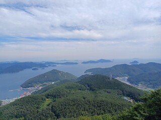 Obraz premium Panoramic View of Korean Islands and Coastline with Blue Sea, Forested Mountains, and Scenic Horizon