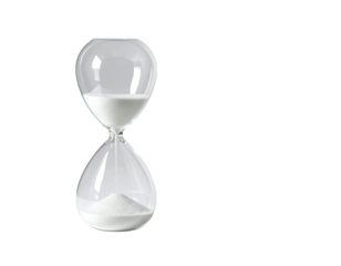 Clear hourglass with white sand, almost empty upper bulb