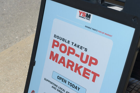 close-up of YSM's Double Take Thrift Store sidewalk sign outside 310 Gerrard St E, Toronto