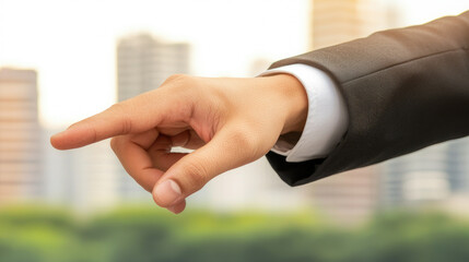 Business professional hand points forward, symbolizing direction and leadership against blurred cityscape background. image conveys confidence and purpose in corporate environment
