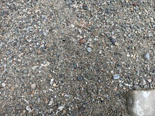 Close-Up of Gravel and Sand Texture. Detailed view of natural gravel and sand surface with mixed small stones, perfect for backgrounds, textures, and design projects