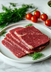 Fototapeta premium Three slices of raw beef steak on a white plate, garnished with fresh dill and cherry tomatoes.