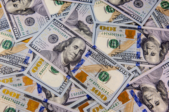 Pile of hundred dollar bills scattered on a flat surface in a well-lit room capturing the essence of wealth and finance in modern society