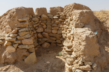 Ancient ruins of a mud and stone structure in Kunduz Province, Afghanistan under a hot hazy sky