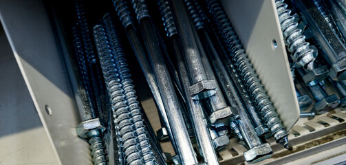 Close-up of assorted metallic bolts and fasteners stored in a toolbox at a hardware workshop during...