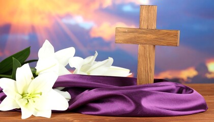 Wooden cross, lilies, and purple cloth on table
