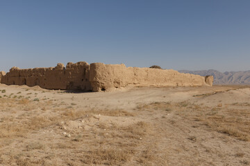 Ancient mud brick fortress ruins in Balkh Province, Afghanistan with a distant mountain range