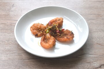 deep fried salty river shrimp with chop garlic and chili pepper arranging on plate 
