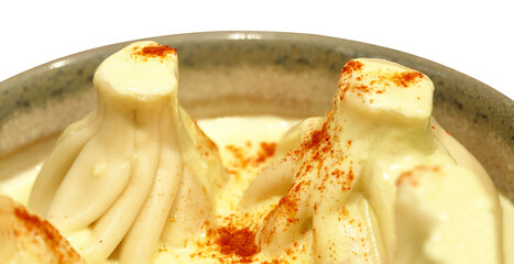 Khinkali in creamy cheese sauce close-up on a plate. Isolated on white background. Food. Transparent background.	