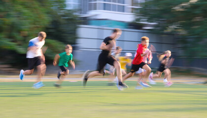 Obraz premium Group of teens running in green park. Blur.