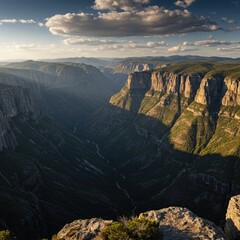 Majestic Sunset View Over Deep Canyon Landscape Dramatic Shadows and Golden Light Illuminate Steep Cliffs Lush Green Vegetation Rocky Outcrop in