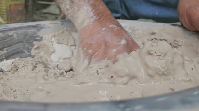 Indian Sculptor artist mixing plaster of paris in water to make sculpture, Odisha, India