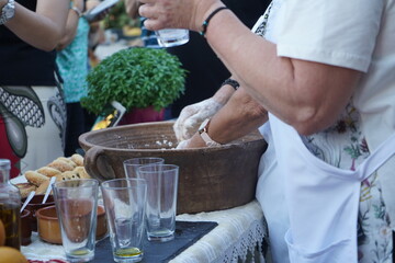Handcrafted delights: a woman kneading dough outdoors in a traditional Cretan setting, perfect for food and travel content.

