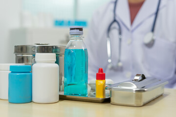 Medical supplies, blue liquid, white bottle, yellow dropper, stainless tray, doctor, hospital