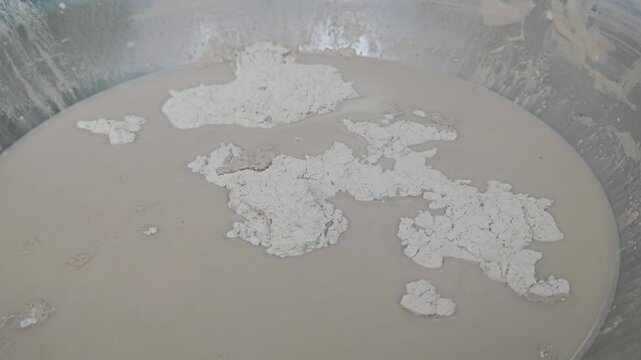 Indian Sculptor artist mixing plaster of paris in water to make sculpture, Odisha, India