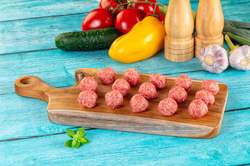 Raw beef meatballs over board
