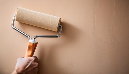 Obraz premium paint roller applying beige paint on wall suitable for home renovation blogs diy websites construction business marketing interior design presentations and how to guides repair service