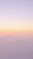Fototapeta premium Serene Mountain Landscape at Sunrise with Softly Blended Hues of Pastel Pink and Orange Above Shrouded Peaks, Creating a Dreamlike Atmosphere