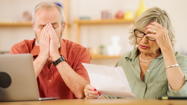 Senior couple worried while reading documents at home