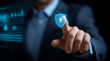 A holographic cybersecurity dashboard glows with shield and lock icons data grids flashing behind as a businessman activates protective barriers with a touch. The scene conveys