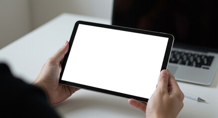 Person Holding Tablet with Blank White Screen at Desk