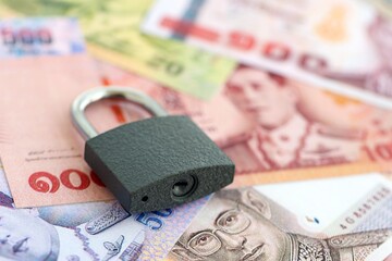 Thai baht currency money bills and padlock. The concept of sanctions and financial safety
